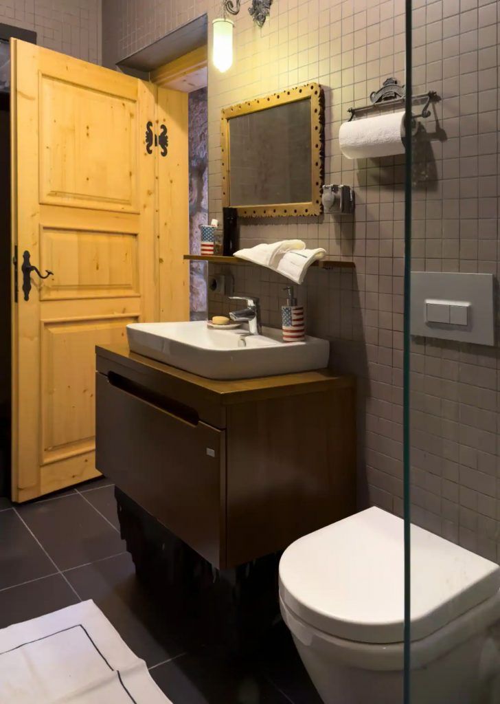 Ahşap dolaplı, sarı kapılı ve duşakabinli banyo